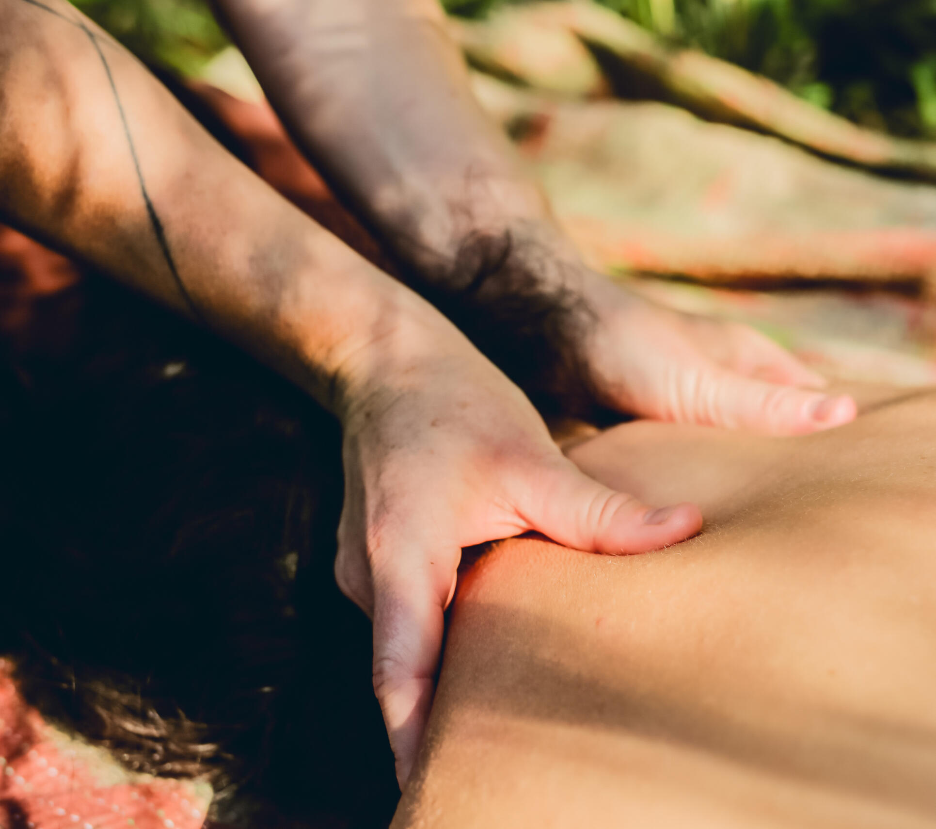 Back massage in the sun Close-up of hands easing tension along the back in soft sunlight