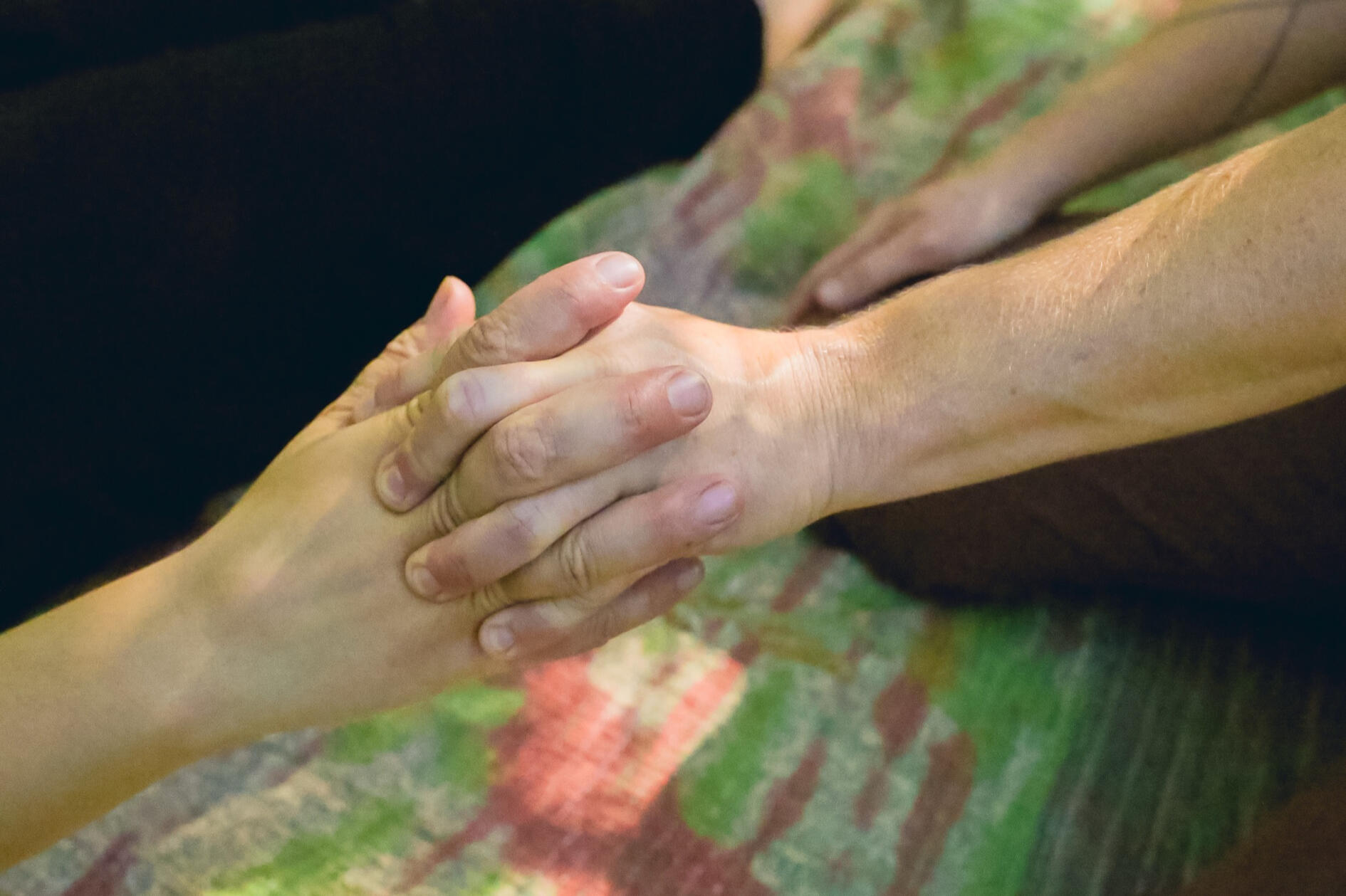 Hands clasped together in a moment of connection during a session