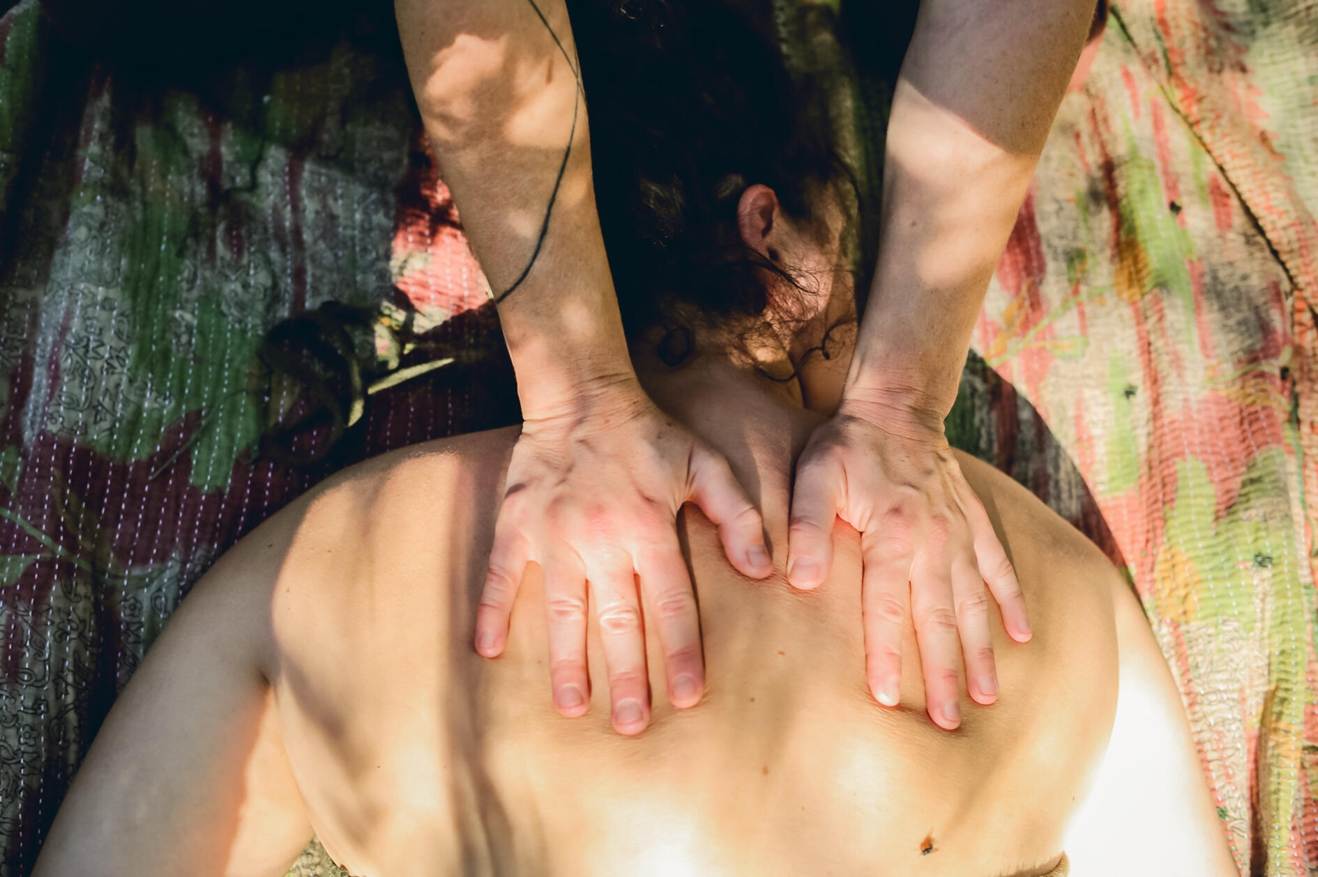 Both palms resting on the upper back and shoulders