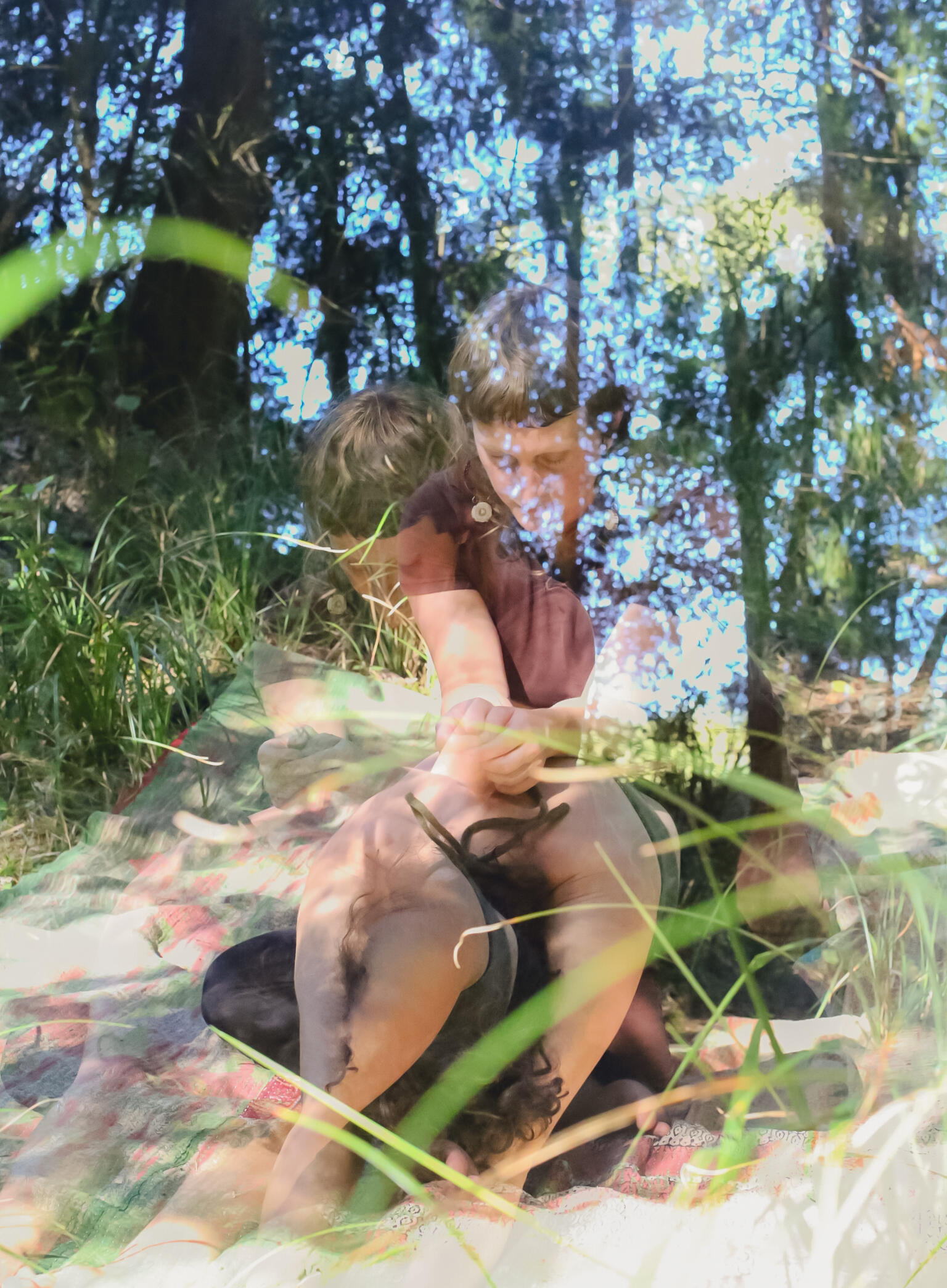 Fae's hand resting on a client's back during an outdoor bodywork session